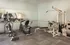 Modern fitness room featuring state-of-the-art exercise equipment, including elliptical machines and strength training equipment, with bright, inviting ambiance.