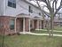 Inviting brick apartment exterior with manicured lawns and covered entryways.