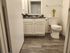 Elegant bathroom with modern sink, toilet, and wood-style flooring.