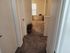 Inviting hallway with plush carpet and elegant d&eacute;cor leading to sunlit rooms.