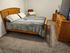 Inviting bedroom with warm wooden furniture, plush carpeting, and modern amenities.
