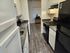 Sleek kitchen with white cabinets, dark countertops, and stainless steel appliances.