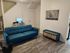 Contemporary living room featuring a blue sofa, sleek workspace, and elegant decor.