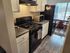 Bright kitchen featuring modern appliances, a sleek black stove, and a charming dining nook with natural light.