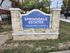 Inviting stone entrance sign for Springdale Estates Apartment Homes surrounded by greenery.