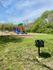 Serene park setting with vibrant playground and convenient BBQ grill, perfect for family gatherings and outdoor fun.
