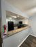 Modern kitchen with sleek granite countertops, stylish white cabinets, and contemporary appliances, offering an inviting open layout.