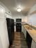 Modern kitchen with sleek black appliances, granite countertops, and elegant white cabinets.