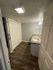 Modern bathroom design featuring sleek wooden flooring, granite countertop, and elegant lighting.