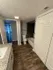 Elegant bathroom with granite countertop, modern bathtub, and stylish wood flooring, leading to a well-lit hallway.