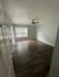 Inviting room with elegant wood flooring, ambient natural light, and a modern ceiling fan, perfect for versatile living.
