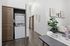 Bright apartment with a sleek in-unit laundry setup, modern decor, and elegant wood flooring, perfect for contemporary living.