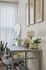 Chic home office space featuring a sleek desk with a modern chair, elegant table lamp, and thriving potted plants, perfect for productivity and style.