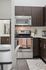Modern kitchen with sleek dark wood cabinets, stainless steel appliances, and stylish decor accents.