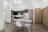 Modern kitchen and dining area featuring sleek cabinetry, stainless steel appliances, and a stylish dining setup, perfect for entertaining.