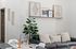 Modern living space featuring a cozy sofa with decorative pillows, contemporary wall art, and a lush indoor plant creating an inviting atmosphere.