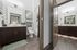Elegant dual bathroom layout featuring modern dark wood cabinetry, sleek mirrors, and soft lighting for a luxurious appeal.