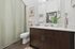 Modern bathroom featuring sleek wood cabinetry, elegant fixtures, and tasteful decor for a refreshing atmosphere.