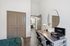 Chic bedroom with modern desk setup, stylish wall mirror, and elegant double doors leading to a luxurious en-suite bathroom.