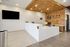 Modern office reception area with stylish wood-paneled wall, sleek white desk, and large wall-mounted TV, creating a welcoming and professional atmosphere.
