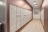 Modern apartment mailroom with contemporary design and sleek mailboxes, illuminated by stylish lighting.
