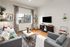 Inviting living room featuring modern gray sofas, elegant decor, and natural light pouring in from a large window.