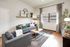 Bright and inviting living room with modern grey sofas, stylish decor, and large window for natural light.