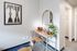 Chic apartment corner with a minimalist desk setup, stylish artwork, and ample natural light, perfect for a cozy home office.