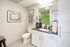 Bright and modern bathroom with sleek cabinetry, fresh decor, and a vibrant green shower backdrop.