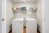 Modern laundry room with sleek washer and dryer, enhanced by stylish shelving for storage and decor.