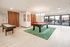 Bright and spacious recreation room featuring a modern pool table, shuffleboard, and stylish seating, perfect for socializing and relaxation.