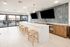 Modern kitchen with a sleek marble island, elegant bar stools, and large sliding glass doors opening to a spacious terrace.