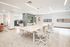 Modern office space with a large conference table, stylish chairs, and ample natural light, ideal for creative collaboration.
