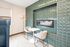 Chic modern nook with stylish green tiled accent wall, elegant seating for two, and unique lighting for a cozy ambiance.