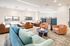 Bright and inviting communal living space with stylish sofas, modern lighting, and large windows offering city views.