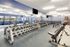 Modern fitness center equipped with state-of-the-art exercise machines, free weights, and ample space, offering an ideal workout environment.