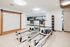 Bright and modern fitness room featuring state-of-the-art reformer Pilates machines, vibrant exercise balls, and sleek design elements.