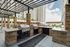 Luxurious outdoor grilling area with modern stone countertops, sleek BBQ grills, and spacious seating under a stylish pergola.