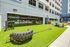 Vibrant outdoor fitness space with modern equipment and lush green turf, perfect for workouts with a view of the pool in a stylish apartment complex.