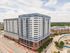 Modern high-rise apartment building with sleek design, offering city views and convenient urban living.