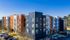 Modern apartment complex showcasing vibrant architecture with multi-colored facades, ample parking, and inviting surroundings.