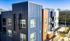Modern apartment complex with striking blue and orange exterior, large windows, and private balconies at 319 Bragg.
