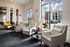 Elegant and spacious apartment lounge with modern seating, large windows, and abundant natural light.