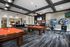 Modern recreation room featuring stylish billiard tables, vibrant gaming area, and sleek lounge space with multiple TVs.