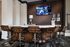 Contemporary recreation room featuring a stylish bar area with leather stools, perfect for entertainment and relaxation.