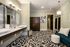 Elegant bathroom with dual sinks, stylish lighting, and a chic patterned floor, perfect for luxurious living.