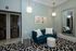 Chic apartment lounge with a modern blue sofa, elegant lighting, and artistic decor for a stylish living space.