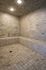 Luxurious spa-style steam room featuring elegant stone walls, ambient lighting, and a relaxing tile seating area.