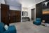 Modern apartment interior featuring stylish dark wood cabinetry, chic blue seating, and elegant decor elements.