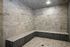Luxurious spa-like modern steam room featuring elegant stone tiles and ambient lighting for ultimate relaxation.
